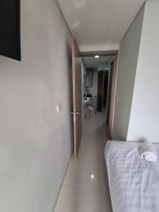 ein Schlafzimmer mit einem weißen Bett und ein Flur in der Unterkunft Seaview gold coast pik bisnis room in Jakarta