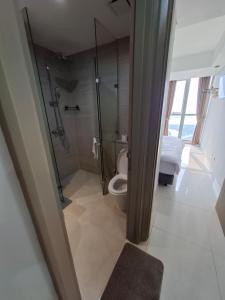 ein Badezimmer mit Dusche und Toilette in der Unterkunft Seaview gold coast pik bisnis room in Jakarta