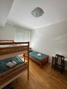 a bedroom with two bunk beds and a chair at Apartment Mucic in Mostar