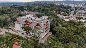 an aerial view of a large white house with a red roof at Lindo Flat no Serra Class com Piscina e Sauna in Canela