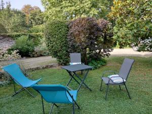 three chairs and a table in the grass at Les Mulotières in Olivet