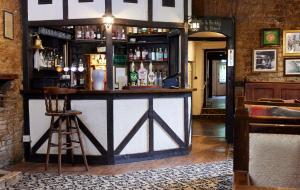 a bar in a pub with a bar stool at Hunters Hall Inn by Greene King Inns in Kingscote