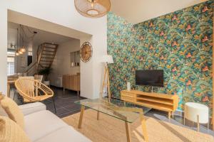 a living room with a couch and a tv at 3 bedroom house with garden, near tram in Mouvaux