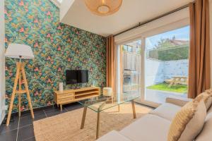 a living room with a tv and a glass table at 3 bedroom house with garden, near tram in Mouvaux