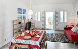 Una sala de estar con una mesa y un sofá rojo. en Nice Home In Plaka With House Sea View, en Plaka