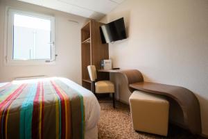 a hotel room with a bed and a desk and a window at Brit Hotel Le Kerann Nantes St Herblain - Zac De La Lorie in Saint-Herblain