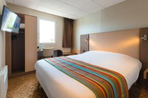 a hotel room with a large bed and a desk at Brit Hotel Le Kerann Nantes St Herblain - Zac De La Lorie in Saint-Herblain