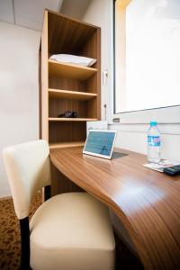 an office desk with a laptop and a chair at Brit Hotel Le Kerann Nantes St Herblain - Zac De La Lorie in Saint-Herblain