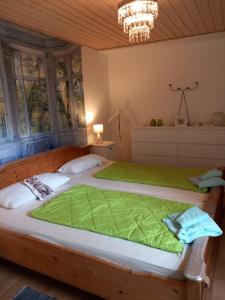 a bedroom with a large wooden bed with green sheets at Villa Sommersted Tanja Blixen in Sommersted