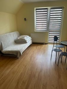 sypialnia z łóżkiem i drewnianą podłogą w obiekcie DW Delfinek w Ustce
