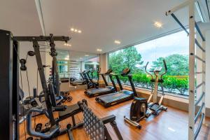 a gym with several tread machines and a large window at Hotel Laghetto Siena Gramado in Gramado