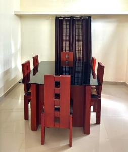 a dining room table with red chairs and a black table and chairsktop at Spacious Beach Side House - Joyce Cottage Kerala in Trivandrum +23 photos