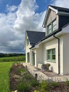 a white house with a pathway leading to it at Endeavour Guest House in Aberdeen