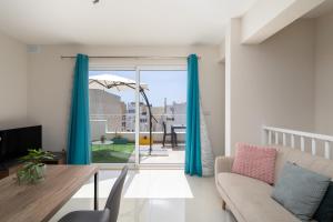 a living room with a couch and a table at Sunlit Stylish Penthouse with Hot Tub - Close to Sliema Promenade, St Julian's & St Georges Bay in Il-Gżira