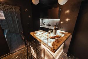 a kitchen with a marble counter top and a sink at Suite Intemporelle in Montagnac