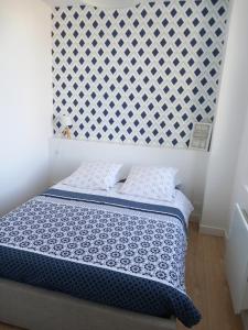 1 dormitorio con 1 cama con cabecero blanco en T2 au centre de Saint-Palais-Sur-Mer, en Saint-Palais-sur-Mer