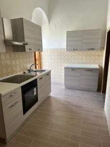 a kitchen with a sink and a stove top oven at Dimora Piazza Imperiale in Poggio Imperiale