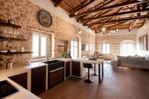 a large kitchen with a sink and a table at Wood and Stone Town Ηouse in Egina