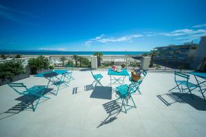 a group of chairs and tables on a patio at Palazzo Novecento in Margherita di Savoia