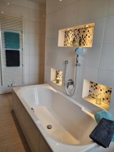 Una gran bañera blanca en un baño. en Ferienhof Haslach, en Immenstadt im Allgäu