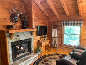 un soggiorno con camino in una baita di tronchi di Two Bears Cabin a Blue Ridge