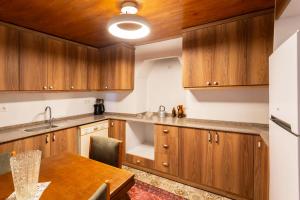 a kitchen with wooden cabinets and a wooden table at Zeytinli Taş Ev in Konak