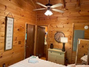 una camera da letto con un letto e un orologio sul muro di Two Bears Cabin a Blue Ridge