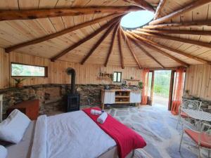 a large room with a bed and a stove at Eco Roundhouse Quinta Carapeto in São Luis +6 photos