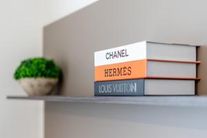 a stack of books on a shelf with a plant at Bright and Modern 2 Bedroom Apartment in Is-Swieqi
