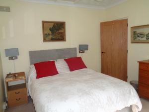 a bedroom with a bed and a wooden door at Jordan Cottage in Fowey