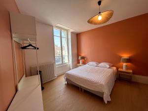 a bedroom with a bed and a large window at Chez Romain - Appartement au coeur de Meursault in Meursault
