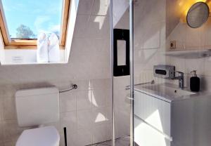 ein Badezimmer mit Toilette und Waschbecken und einem Fenster in der Unterkunft Kostengünstige & charmante Ferienunterkunft ohne Küche und in Strandnähe - Ideal für Kurztrips oder 1-Nacht Aufenthalte in Scharbeutz + 25 Fotos