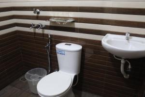 a bathroom with a toilet and a sink at Anna Hotel in Trivandrum