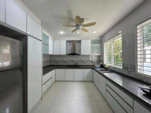 a kitchen with white cabinets and a ceiling fan at Landed House Gelugor 5BR 3B-20pax by 3C in Gelugor
