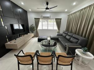 a living room with a couch and a table and chairs at Landed House Gelugor 5BR 3B-20pax by 3C in Gelugor