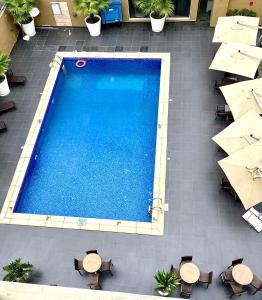 an overhead view of a swimming pool with tables and umbrellas at The Sojourner By Genesis in Ikeja