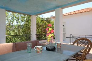 a table with a vase of flowers on a patio at Mamma Mia in Skopelos Town