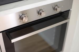 a black and white oven with silver knobs at Nyrenoverad lägenhet med perfekt läge nära Elmia in Huskvarna