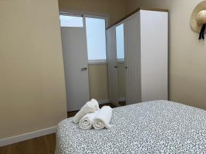 a bedroom with a bed with towels on it at Playa América-Sal y Arena in Nigrán +10 photos