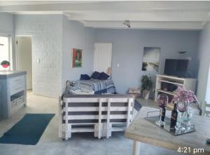 a living room with a couch and a table at Cottage on Atlantic90 in Yzerfontein