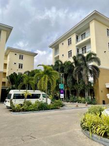 a white van parked in a parking lot in front of a building at The Sojourner By Genesis in Ikeja