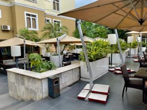 a patio with tables and chairs and umbrellas at The Sojourner By Genesis in Ikeja
