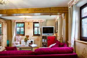 a living room with a red couch and a tv at Ferienwohnung-Cottage Rhöner Kräute in Buttlar