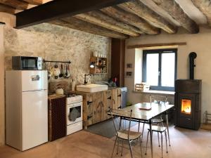 a kitchen with a white refrigerator and a table at L'étable du Vercors in Saint-Agnan-en-Vercors