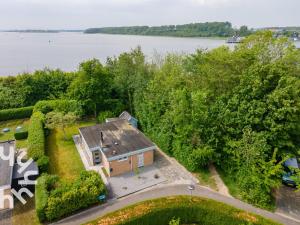 an overhead view of a house on the shore of a lake at Vrijstaande vakantiewoning dichtbij het Veerse Meer in Wolphaartsdijk