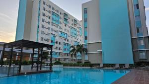a large apartment building with a large swimming pool at Khael's City Oasis at Marina Spatial in Dumaguete