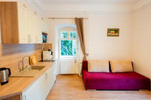 a kitchen with a red bench in the middle of it at Carlone House in Eger
