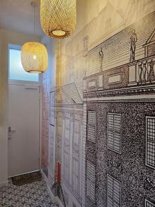 a hallway with a mural of a building on the wall at Elégante maison amiénoise - proche gare, home-cinéma, 3 chambres doubles, 1 chambre familiale avec jacuzzi privatif - La Maison Des Petits Sablon in Amiens