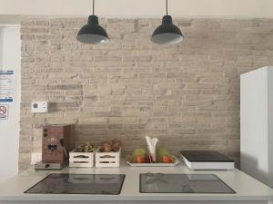 a kitchen counter with two lights and a brick wall at Affittacamere La Torre in Biccari