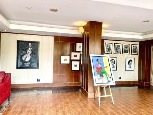 a painting on a stand in a room with pictures at The Sojourner By Genesis in Ikeja